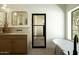 Bright bathroom features a soaking tub, modern vanity, and black framed glass door at 8910 E Topeka Dr, Scottsdale, AZ 85255
