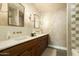 Bathroom featuring double sinks, dark wood cabinets, and unique wall sconces at 8910 E Topeka Dr, Scottsdale, AZ 85255