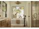 Bathroom featuring a soaking tub, matte black fixtures, and a view of the backyard at 8910 E Topeka Dr, Scottsdale, AZ 85255