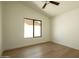 Empty bedroom features hardwood flooring, ceiling fan, and a bright window at 8910 E Topeka Dr, Scottsdale, AZ 85255