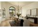 Bright dining room boasts large windows, modern chandelier, and seating for eight at 8910 E Topeka Dr, Scottsdale, AZ 85255