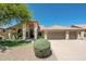 An inviting home with mature landscaping, a tile roof and a circular driveway at 8910 E Topeka Dr, Scottsdale, AZ 85255