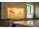 Close up of gourmet range in kitchen, with custom hood, stone accent wall and countertop space at 8910 E Topeka Dr, Scottsdale, AZ 85255