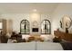 Inviting living room with modern fireplace, arched doors, neutral tones, and comfortable seating at 8910 E Topeka Dr, Scottsdale, AZ 85255