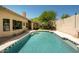 Backyard pool featuring a Baja step and mature landscaping under a clear blue sky at 8910 E Topeka Dr, Scottsdale, AZ 85255
