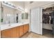Bright bathroom with double vanity, large mirror and a walk-in closet at 8968 W Adam Ave, Peoria, AZ 85382