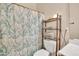 Bathroom featuring a bathtub-shower with curtain, toilet and a shelve with towels and decorations at 8968 W Adam Ave, Peoria, AZ 85382