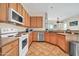 Functional kitchen with updated appliances, wood cabinetry and breakfast bar at 8968 W Adam Ave, Peoria, AZ 85382