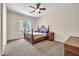 Spacious primary bedroom with a decorative bed frame, neutral carpet, and a ceiling fan at 8968 W Adam Ave, Peoria, AZ 85382