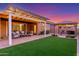 Spacious backyard with a covered patio, gazebo, artificial turf, and cozy seating area at 9764 E Thornbush Ave, Mesa, AZ 85212