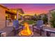 Inviting backyard with a fire pit, outdoor seating, lush landscaping, and a charming gazebo at 9764 E Thornbush Ave, Mesa, AZ 85212