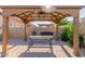 Charming backyard gazebo featuring a picnic table, string lights, and brick-paved flooring at 9764 E Thornbush Ave, Mesa, AZ 85212