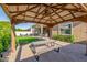 Inviting backyard patio with brick pavers, gazebo, outdoor seating, manicured lawn, and lush plants at 9764 E Thornbush Ave, Mesa, AZ 85212