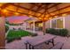 Beautiful backyard featuring an outdoor dining area, pergola, manicured lawn, and fire pit at 9764 E Thornbush Ave, Mesa, AZ 85212