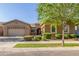 Charming single-story home featuring lush landscaping and a well-manicured lawn at 9764 E Thornbush Ave, Mesa, AZ 85212