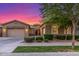 Charming home featuring a three-car garage, well-maintained yard, and beautiful sunset at 9764 E Thornbush Ave, Mesa, AZ 85212
