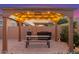 Relaxing gazebo with string lights, picnic table, and grill in a beautifully landscaped backyard at 9764 E Thornbush Ave, Mesa, AZ 85212