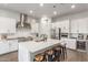 Bright kitchen with white cabinets, quartz island with seating, and stainless steel appliances at 9764 E Thornbush Ave, Mesa, AZ 85212