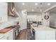 Well-lit kitchen boasts stainless steel appliances, white cabinetry, and a large island with sink at 9764 E Thornbush Ave, Mesa, AZ 85212