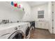 Laundry room features a modern washer and dryer, ample storage shelves, and a utility sink at 9764 E Thornbush Ave, Mesa, AZ 85212