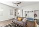 Bright living room with a gray sofa, wooden floors, and a custom storage area with hooks and shelves at 9764 E Thornbush Ave, Mesa, AZ 85212