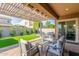 Stylish outdoor patio with comfortable seating, manicured lawn, and a view of the serene backyard at 9764 E Thornbush Ave, Mesa, AZ 85212