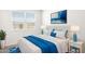 Well-lit bedroom with stylish blue decor and white bedding, creating a serene space at 10608 W Sonrisas St, Tolleson, AZ 85353