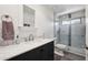 Clean bathroom with large mirror, vanity with marble top, and glass-enclosed shower at 11256 E Sunnyside Dr, Scottsdale, AZ 85259