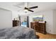 Cozy bedroom with a view of the pool, hardwood floors, wooden dressers, and a ceiling fan at 11256 E Sunnyside Dr, Scottsdale, AZ 85259