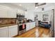 Well-lit kitchen boasts white cabinets, stainless steel appliances, hardwood floors, and views of the backyard at 11256 E Sunnyside Dr, Scottsdale, AZ 85259