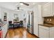 Bright kitchen with stainless steel refrigerator, breakfast bar, hardwood floors, and view of the backyard at 11256 E Sunnyside Dr, Scottsdale, AZ 85259