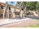 Exterior view of a two-story apartment complex with staircases, trees, and stucco walls at 1126 W Elliot Rd # 2023, Chandler, AZ 85224