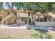 Complex featuring staircases leading to the apartments, complemented by lush trees and stucco at 1126 W Elliot Rd # 2023, Chandler, AZ 85224