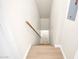 Hallway with wooden stairs and handrail leading to an upstairs or downstairs area, with a white wall at 1126 W Elliot Rd # 2023, Chandler, AZ 85224