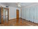 Bedroom with hardwood floors, white walls, ceiling fan, and view into the hallway at 1134 W Portland St, Phoenix, AZ 85007