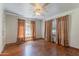 Bedroom featuring hardwood floors, white walls, a ceiling fan, and brown curtains at 1134 W Portland St, Phoenix, AZ 85007