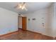 Bedroom featuring hardwood floors, white walls, ceiling fan, and hallway access at 1134 W Portland St, Phoenix, AZ 85007