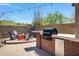 Outdoor kitchen features granite countertops, stainless steel grill, and a built-in mini fridge at 12118 W Dove Wing Way, Peoria, AZ 85383