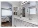 Bright bathroom featuring a double sink vanity with a large mirror and access to the bedroom at 12118 W Dove Wing Way, Peoria, AZ 85383