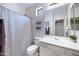 Clean bathroom featuring a shower with striped curtain, vanity with ample lighting and storage at 12118 W Dove Wing Way, Peoria, AZ 85383