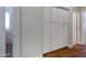 Hallway features ample storage with large, built-in white cabinets and hardwood floors at 12118 W Dove Wing Way, Peoria, AZ 85383