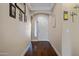 Welcoming hallway with dark wood flooring and neutral walls, with arched entryway at 12118 W Dove Wing Way, Peoria, AZ 85383
