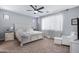 Serene main bedroom with neutral tones, plush carpet, and a ceiling fan at 12118 W Dove Wing Way, Peoria, AZ 85383
