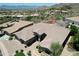 Beautiful aerial perspective of this desert property boasting lush landscaping, a circular drive and inviting curb appeal at 136 E Desert Wind Dr, Phoenix, AZ 85048