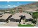 Captivating aerial view of this desert home with paver driveway and lush landscaping, offering an inviting entrance at 136 E Desert Wind Dr, Phoenix, AZ 85048