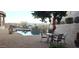 Outdoor patio with table and chairs, a pool and spa with outdoor kitchen and amazing mountain views from the backyard at 136 E Desert Wind Dr, Phoenix, AZ 85048