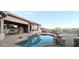 View of sparkling pool and spa with beautiful patio, outdoor kitchen and lovely mountain views from the backyard at 136 E Desert Wind Dr, Phoenix, AZ 85048