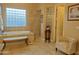 Spacious bathroom featuring a soaking tub, large window, seating, and stylish decor at 136 E Desert Wind Dr, Phoenix, AZ 85048