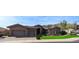 Elegant home exterior with a three-car garage, manicured lawn, and stone accents, nestled in a scenic neighborhood at 136 E Desert Wind Dr, Phoenix, AZ 85048