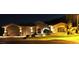 Stunning home exterior at night, featuring well-lit landscaping, a three-car garage, and an inviting entrance at 136 E Desert Wind Dr, Phoenix, AZ 85048